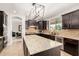 Gourmet kitchen with dark cabinetry, stainless steel appliances, and a large island with stone countertops at 2460 E Crescent Way, Gilbert, AZ 85298