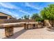 This outdoor kitchen features a built-in grill, refrigerator, sink, and plenty of counter space for entertaining at 2460 E Crescent Way, Gilbert, AZ 85298