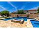 Backyard pool and spa area with a water feature, basketball hoop, in-pool fire pit, and lounge chairs at 2460 E Crescent Way, Gilbert, AZ 85298