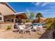 Backyard features outdoor kitchen, covered patio, pool, lush landscaping, and comfortable seating area at 24813 N 55Th Dr, Glendale, AZ 85310