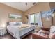 Relaxing bedroom with light walls, a plush bed, beach-themed decor, and a cozy leather loveseat at 24813 N 55Th Dr, Glendale, AZ 85310