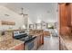 Open kitchen with granite countertops, stainless steel appliances, and seamless flow into the living area at 24813 N 55Th Dr, Glendale, AZ 85310