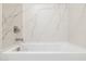 Close-up of a modern bathtub with white marble surround and sleek faucet fixtures at 25096 N 154Th Ln, Surprise, AZ 85387
