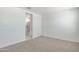 A well-lit bedroom with neutral carpet adjacent to a bathroom with a glass shower enclosure at 25096 N 154Th Ln, Surprise, AZ 85387