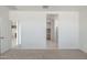 A bedroom shows access to bathroom with glass shower and access to kitchen with wood cabinets at 25096 N 154Th Ln, Surprise, AZ 85387