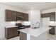 Well-equipped kitchen features stainless steel appliances, island with quartz countertops, and wood cabinets at 25096 N 154Th Ln, Surprise, AZ 85387