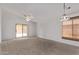 Large living room featuring vaulted ceilings, neutral carpet, ceiling fan, and sliding glass door at 330 S Valley Dr, Apache Junction, AZ 85120