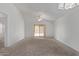 Spacious living room featuring neutral carpet, ceiling fan, sliding glass door and vaulted ceiling at 330 S Valley Dr, Apache Junction, AZ 85120