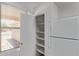 Pantry area featuring a white refrigerator and wooden shelving, with a window to the exterior at 330 S Valley Dr, Apache Junction, AZ 85120