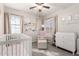 This Bedroom is bright and airy, featuring a crib, changing table, and comfortable armchair at 34913 N 30Th Dr, Phoenix, AZ 85086