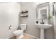 Stylish half-bathroom with pedestal sink, decorative mirror, and neutral decor at 34913 N 30Th Dr, Phoenix, AZ 85086