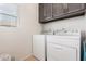 A functional laundry room includes a washer, dryer, and ample cabinet space at 34913 N 30Th Dr, Phoenix, AZ 85086