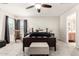 This main bedroom features a ceiling fan, rocking chair, and an adjacent bathroom at 34913 N 30Th Dr, Phoenix, AZ 85086
