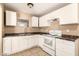 Bright kitchen equipped with efficient appliances, ample countertop space, and white cabinetry at 3802 N 50Th Ave, Phoenix, AZ 85031