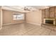 Living room with ceiling fan, tile flooring, stone fireplace, and a large window at 3802 N 50Th Ave, Phoenix, AZ 85031