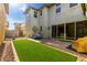 Spacious backyard with artificial grass, patio, and a sliding glass door leading inside at 3910 E Turley St, Gilbert, AZ 85295