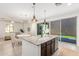 Open kitchen boasts a large island with granite counters, stainless appliances, and sliding glass doors to the backyard at 3910 E Turley St, Gilbert, AZ 85295