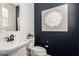 Stylish powder room features an elegant wall-mounted sink, decorative painting, and sophisticated artwork at 3910 E Turley St, Gilbert, AZ 85295