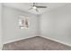 This bedroom features neutral paint, carpet, a ceiling fan, and a window providing natural light at 3933 W Nancy Ln, Phoenix, AZ 85041