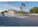 White brick home with covered patio, gravel backyard, and tall palm trees, perfect for outdoor activities at 4031 W Palmaire Dr, Phoenix, AZ 85051