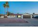 Charming single-story home with a two-car garage, desert landscaping and blue skies at 4031 W Palmaire Dr, Phoenix, AZ 85051