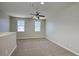 Bright, carpeted room with natural light filtering through windows and a ceiling fan at 4242 E Erie St, Gilbert, AZ 85295