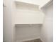A compact walk-in closet provides shelves and racks for storage, with carpeted flooring at 4242 E Erie St, Gilbert, AZ 85295