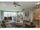 Open-concept living room with modern furnishings, staircase, and tile floors flowing into the kitchen and dining areas at 4242 E Erie St, Gilbert, AZ 85295
