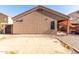 Backyard exterior showcasing stucco walls, minimal landscaping, and covered patio at 42758 W Camino De Janos --, Maricopa, AZ 85138