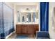 Bathroom with double vanity sinks, framed mirror, and a shower-tub combo with stylish curtain at 42758 W Camino De Janos --, Maricopa, AZ 85138
