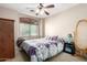 Cozy bedroom with a ceiling fan, bed with patterned linens, and a nightstand at 42758 W Camino De Janos --, Maricopa, AZ 85138