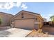 Neutral colored, single story stucco home with a two-car garage and low maintenance desert landscaping at 42758 W Camino De Janos --, Maricopa, AZ 85138