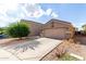 Neutral stucco single story house, two-car garage, and desert landscaping on a sunny day at 42758 W Camino De Janos --, Maricopa, AZ 85138