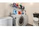Functional laundry area with a washer, dryer, and shelving at 42758 W Camino De Janos --, Maricopa, AZ 85138
