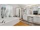 Bright bathroom with a large tub, walk in shower, and wood floors at 4401 E Barwick Dr, Cave Creek, AZ 85331