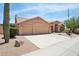 Tan single-story home featuring a three-car garage, desert landscaping and a tile roof at 4401 E Barwick Dr, Cave Creek, AZ 85331