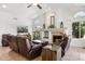 Bright living room featuring a cozy fireplace, tile flooring, and comfortable leather seating at 4401 E Barwick Dr, Cave Creek, AZ 85331