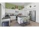 Well-lit kitchen featuring modern appliances, white cabinets, an island with seating, and charming green accents at 4554 E Coyote Wash Dr, Cave Creek, AZ 85331