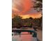 A scenic outdoor patio with a pool, fire pit, chairs and a colorful sunset creating a cozy and inviting atmosphere at 4554 E Coyote Wash Dr, Cave Creek, AZ 85331
