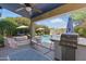 Backyard area with an outdoor kitchen, swimming pool, and patio umbrellas, perfect for summer enjoyment at 4554 E Coyote Wash Dr, Cave Creek, AZ 85331