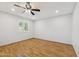 Bright bedroom with hardwood floors, fan, and a window with shuttered blinds at 4808 E Betty Elyse Ln, Scottsdale, AZ 85254
