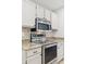 Close up of stainless steel oven and microwave with tile backsplash and granite counters at 4808 E Betty Elyse Ln, Scottsdale, AZ 85254