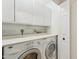 Laundry room with white cabinets, countertop and white appliances at 4808 E Betty Elyse Ln, Scottsdale, AZ 85254