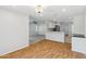 Open-concept living space featuring wood floors, white walls, and a breakfast bar at 4808 E Betty Elyse Ln, Scottsdale, AZ 85254