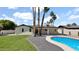 Inviting backyard pool with a sleek, modern design, surrounded by palm trees and lush green grass at 5109 E Blanche Dr, Scottsdale, AZ 85254