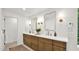Bathroom featuring a double vanity with wooden cabinets, modern fixtures, and stylish mirrors at 5109 E Blanche Dr, Scottsdale, AZ 85254