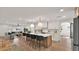 Open kitchen with a center island, bar seating, modern pendant lighting, white cabinetry, and stainless steel appliances at 5109 E Blanche Dr, Scottsdale, AZ 85254