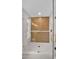Tiled shower with glass door, rainfall shower head, and built-in shelving at 5109 E Blanche Dr, Scottsdale, AZ 85254