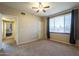 Spacious bedroom with a ceiling fan and large windows with dark curtains at 5345 E Van Buren St # 305, Phoenix, AZ 85008