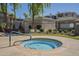 Community hot tub with easy access steps, set in a grassy area near the pool, perfect for relaxation at 5345 E Van Buren St # 305, Phoenix, AZ 85008